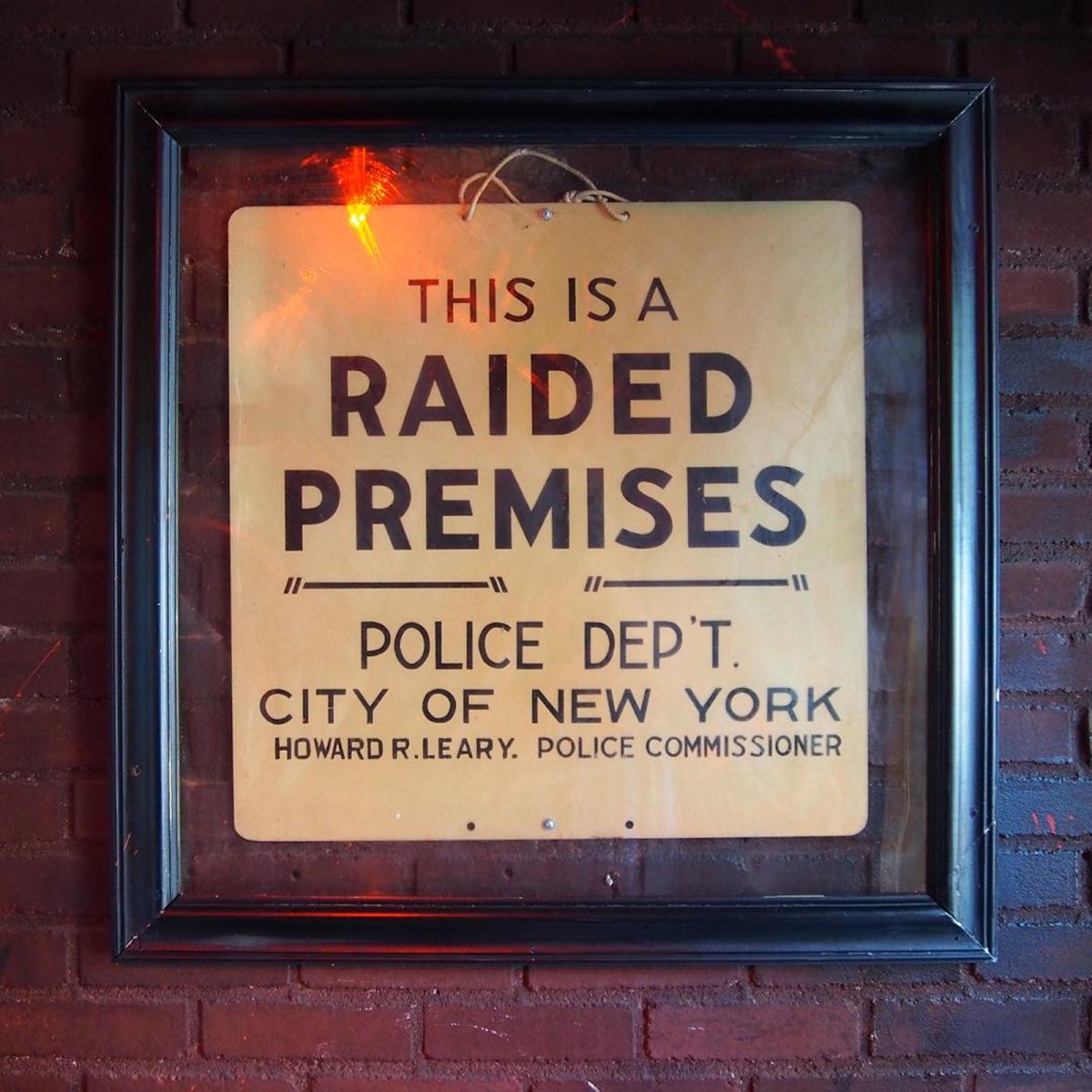 Photo of the “raided premises” sign from the Stonewall riots, on display inside the door at the Stonewall Inn, New York.